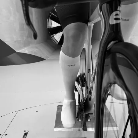 Cycliste en soufflerie portant les couvre-chaussures Spatzwear Windsock2 LONG blancs, vue avant sur vélo de contre-la-montre.
