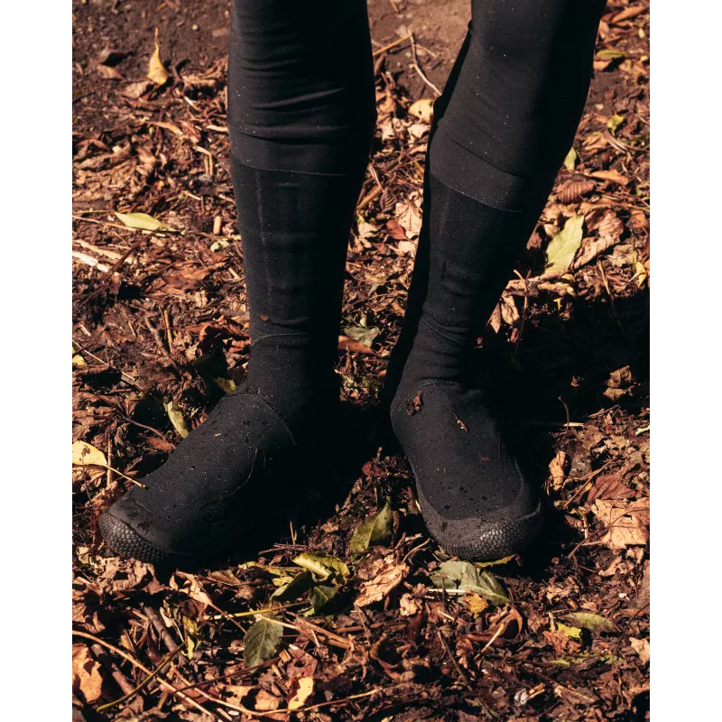 Full view of Spatzwear TUFR2 overshoes worn off-road, on muddy ground with fallen leaves.