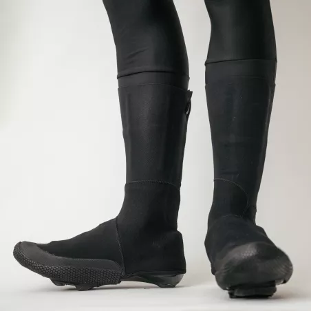 Vue latérale en mouvement des couvre-chaussures Spatzwear TUFR2 noirs, protection intégrale du pied et de la cheville.